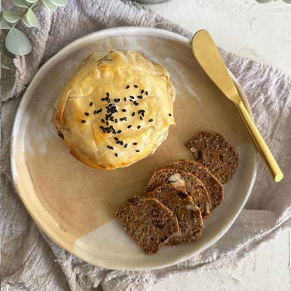 Queso camembert con cebolla caramelizada envuelta en crujiente masa filo. Ideal para un rico picoteo.